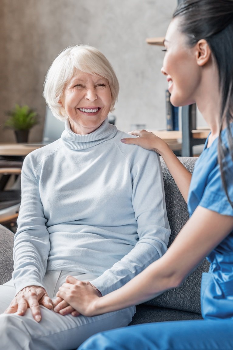 Carer serving tea to elderly man